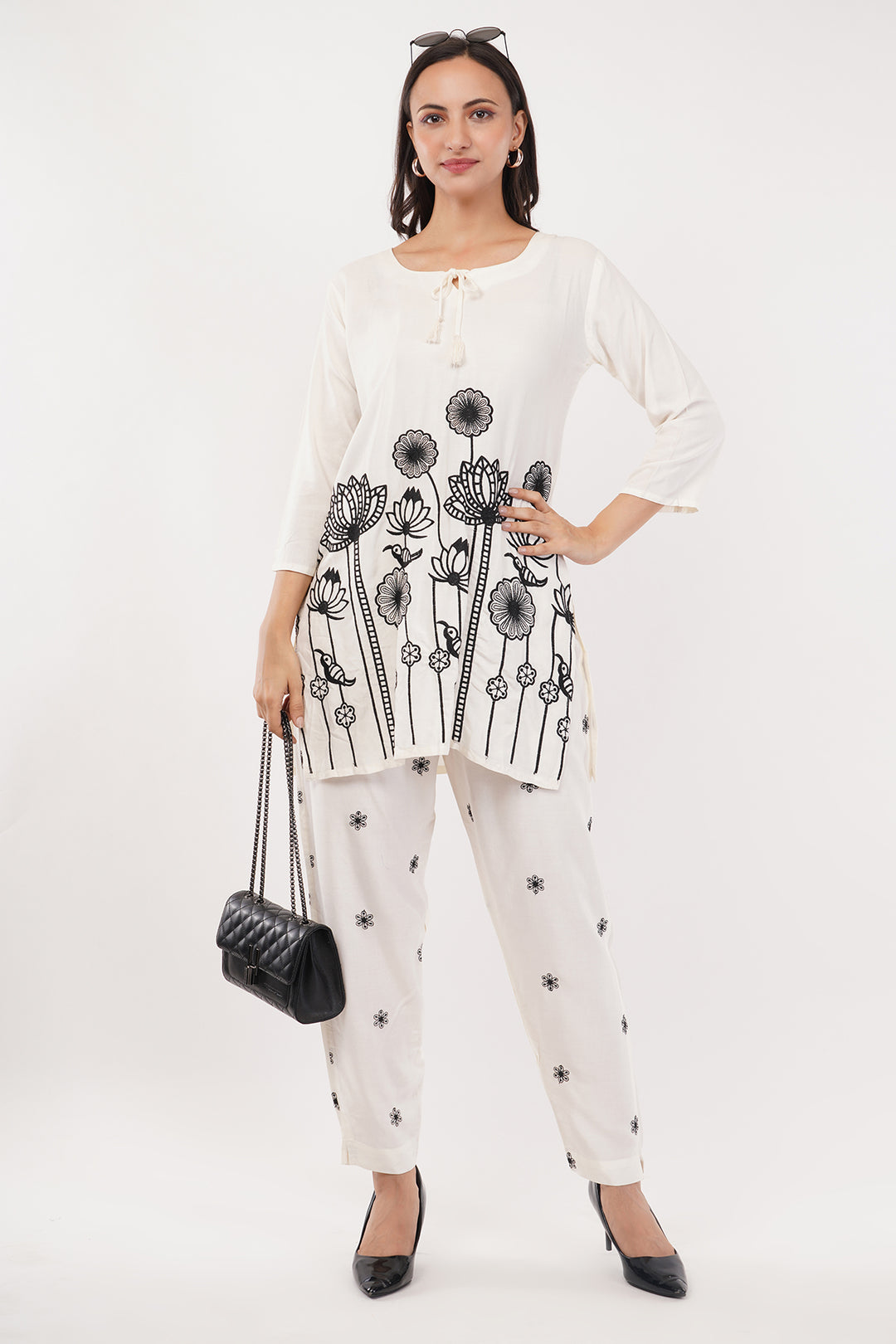 offwhite cord set with black work on the pants